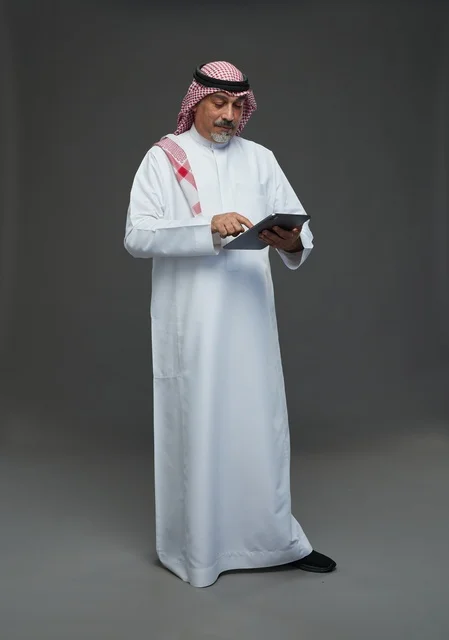 Elderly Saudi Man Using Digital Tablet in Studio