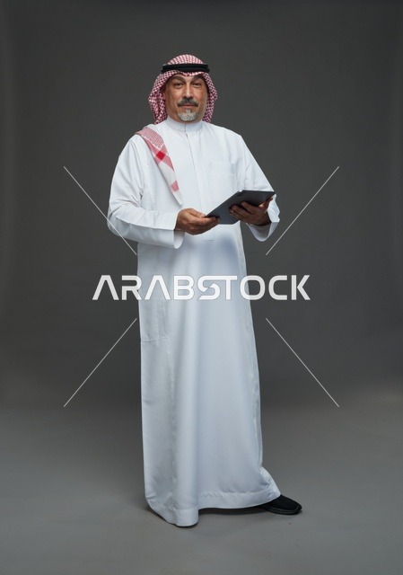 Elderly Saudi Man Using Tablet in Studio