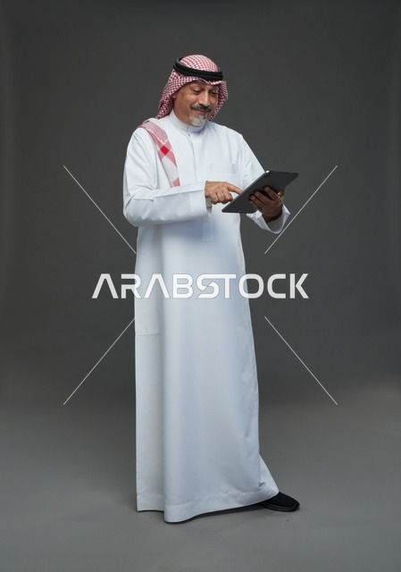 Elderly Saudi Man Using Digital Tablet in Studio