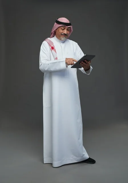 رجل سعودي مسن يستخدم جهاز لوحي في الاستوديو