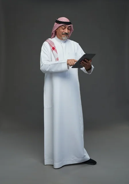 Saudi Senior Man Using Tablet on Grey Background