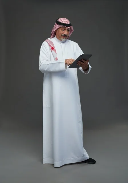 Elderly Saudi Man Using Digital Tablet in Studio