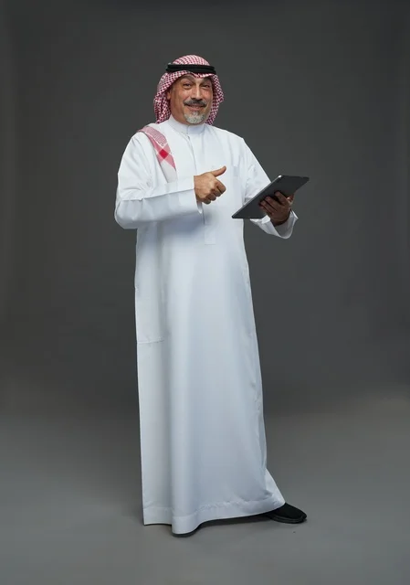 رجل سعودي مسن يستخدم جهاز لوحي بإيماءة نجاح