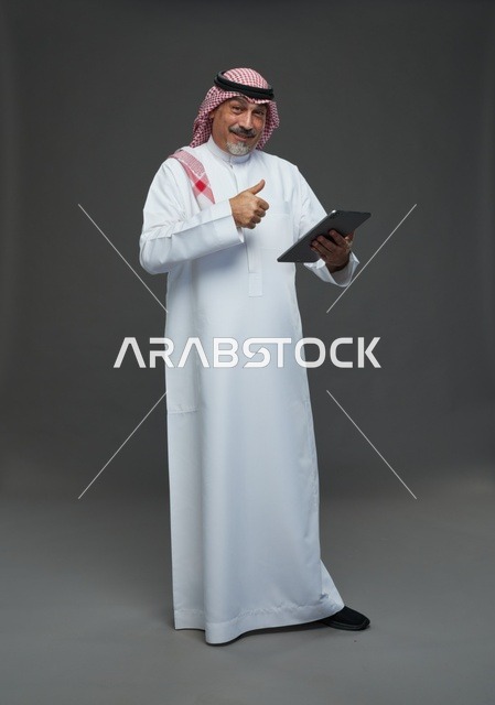 Saudi Elderly Man Using Tablet with Thumbs Up