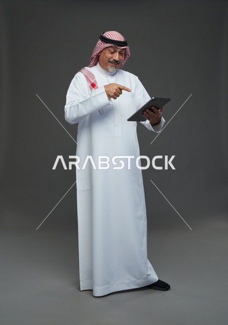 Senior Saudi Man Using Digital Tablet in Studio