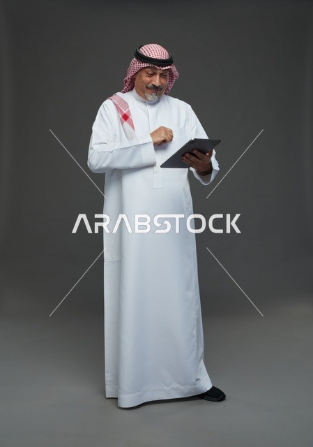 Senior Saudi Man Using Tablet in Studio