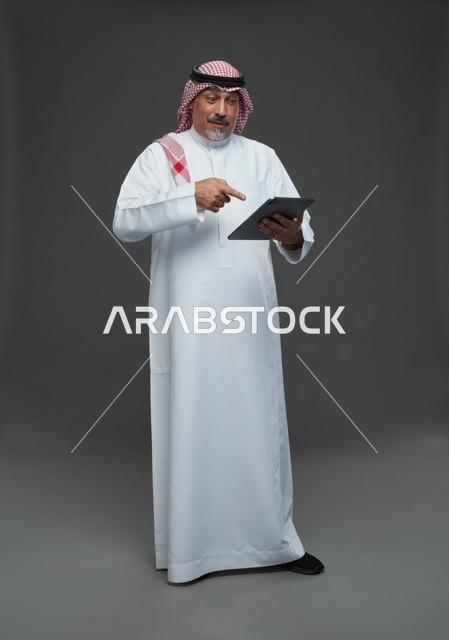 Elderly Saudi man using a tablet device