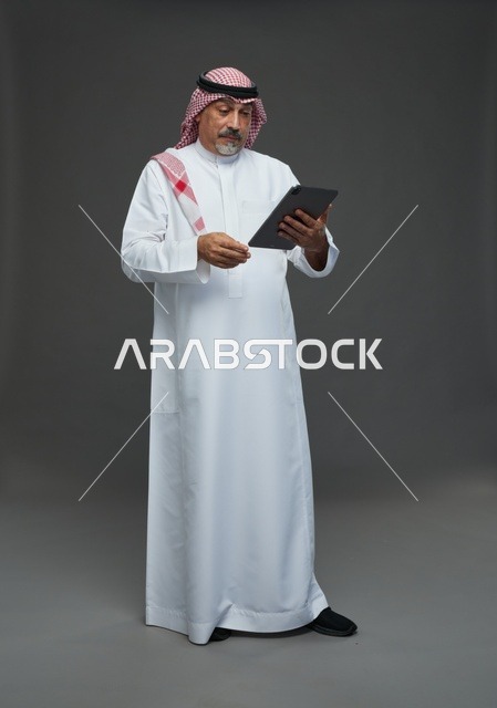 Elderly Saudi man using a tablet device