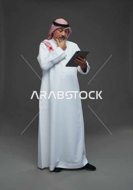 Elderly Saudi Man Using Digital Tablet in Studio