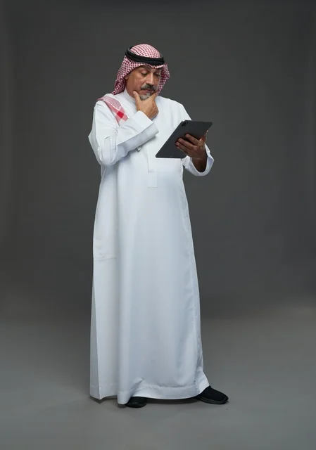 Elderly Saudi Man Using Digital Tablet in Studio