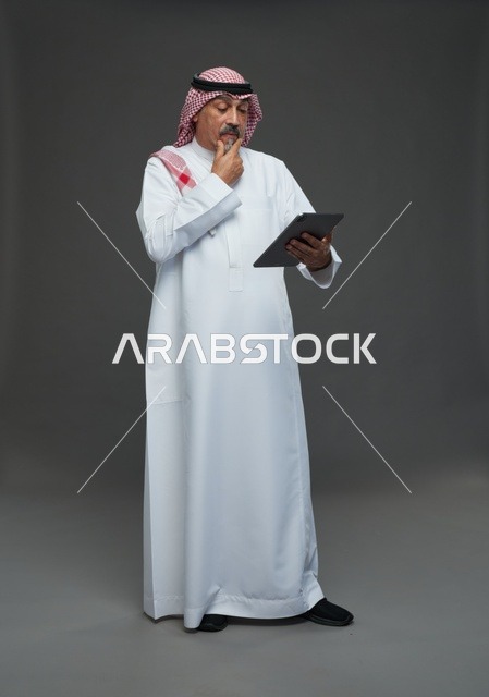 Elderly Saudi Man Using Digital Tablet in Studio