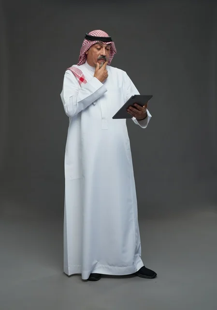 Elderly Saudi Man Using Digital Tablet in Studio