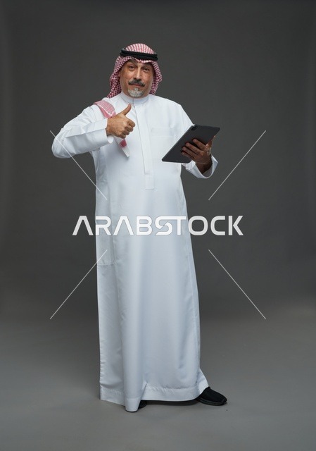 رجل سعودي مسن مع جهاز لوحي وعلامة إعجاب