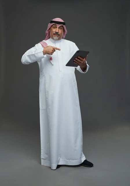 Saudi Senior Man Pointing at Tablet in Studio