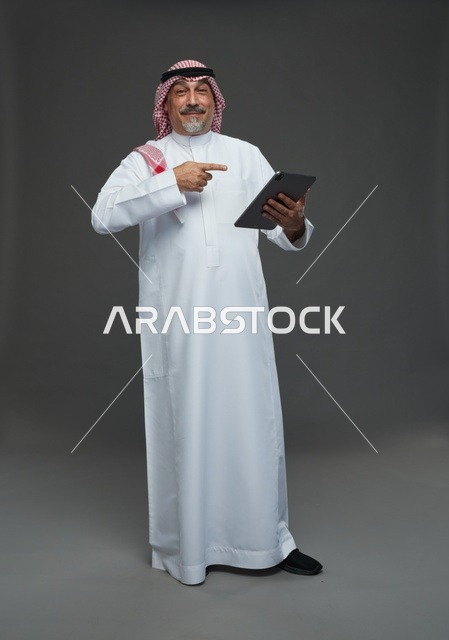 Elderly Saudi Man Using Digital Tablet in Studio