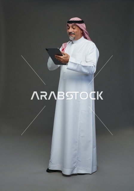 Elderly Saudi Man Using Digital Tablet in Studio