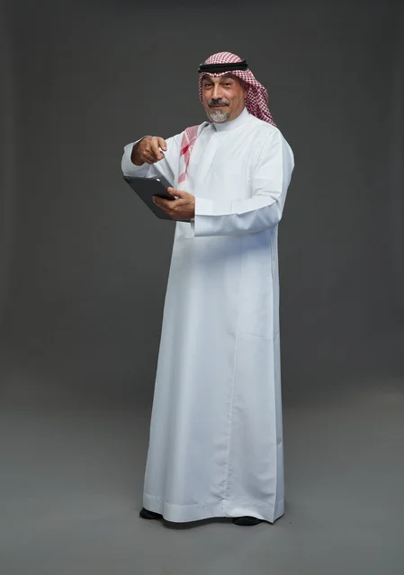 Elderly Saudi Man with Tablet on Grey Background