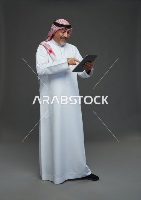 Elderly Saudi Man Using Tablet in Studio