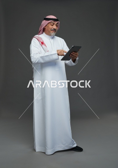 Elderly Saudi man using a tablet device