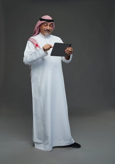 Saudi Elderly Man Using Digital Tablet on Grey Background