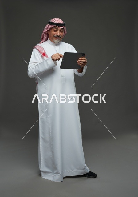 Elderly Saudi man using a tablet device