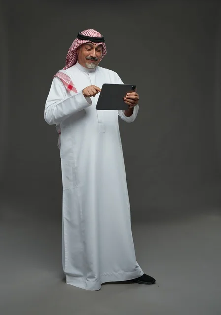 Elderly Saudi man using a tablet device
