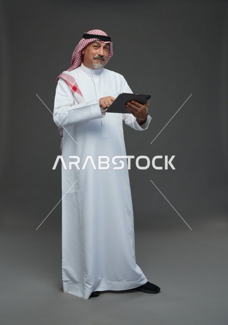 Elderly Saudi Man Using Digital Tablet in Studio