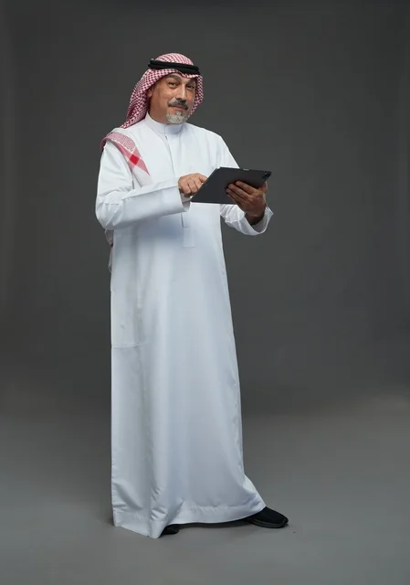 Elderly Saudi Man Using Digital Tablet in Studio