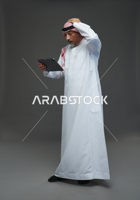 Elderly Saudi Man Worried Using Tablet in Studio