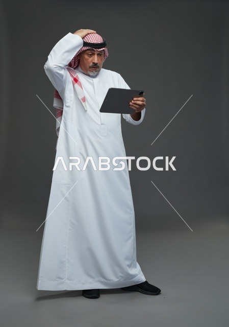 رجل سعودي مسن يستخدم جهاز لوحي في استوديو