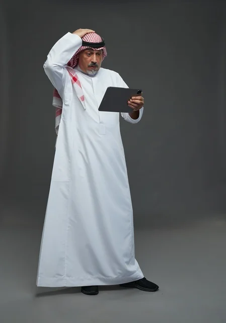 رجل سعودي مسن يستخدم جهاز لوحي في استوديو