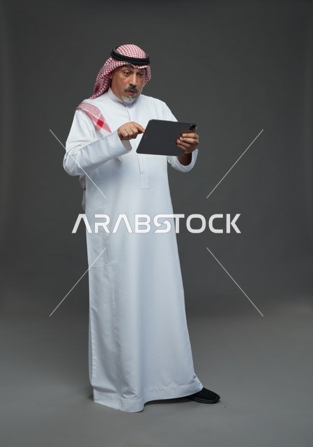Elderly Saudi Man Using Digital Tablet in Studio