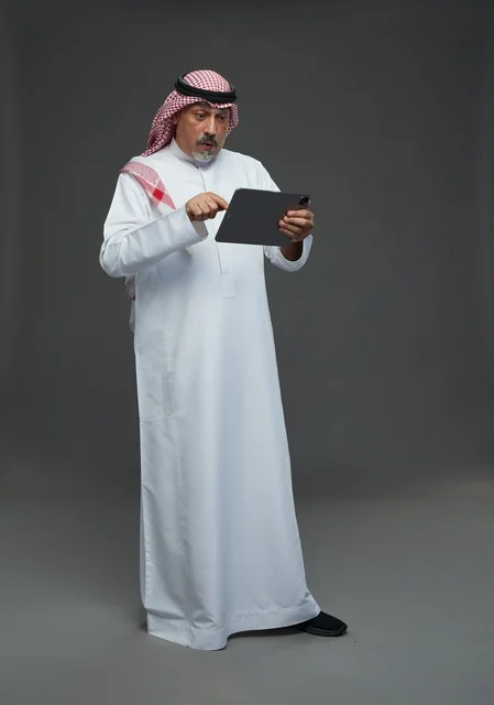Elderly Saudi Man Using Digital Tablet in Studio