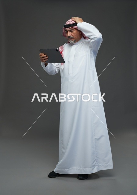 Elderly Saudi Man Using Tablet with Confused Expression