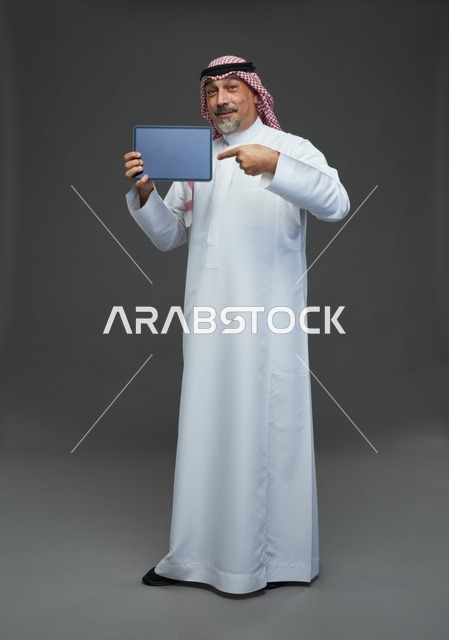Elderly Saudi Man Pointing at Tablet in Studio