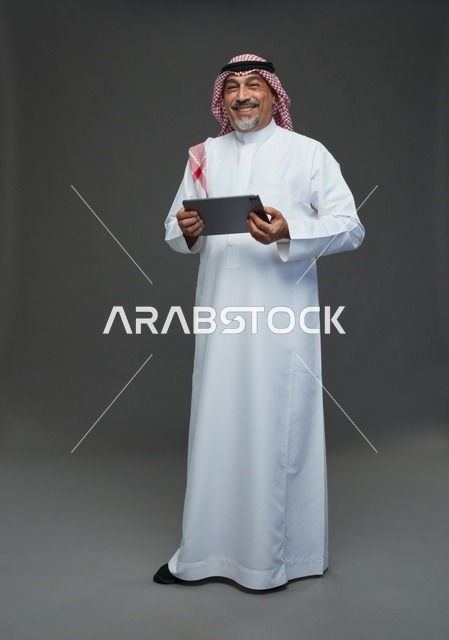 رجل سعودي مسن مع جهاز لوحي في الاستوديو