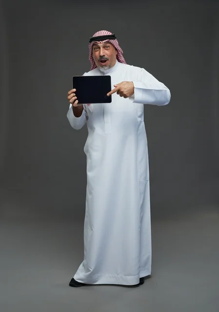 Senior Saudi Man with Digital Tablet on Gray Background
