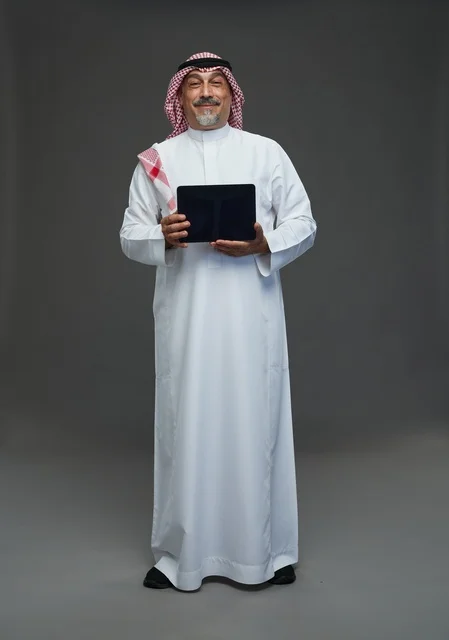 Elderly Saudi Man Holding Digital Tablet in Grey Studio