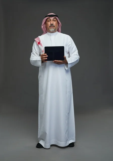 Saudi Elderly Man Holding Digital Tablet on Grey Background