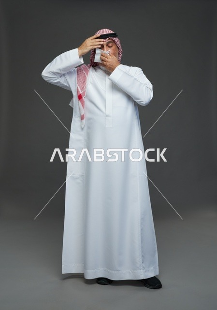 رجل سعودي مسن يعطس في منديل في الاستوديو