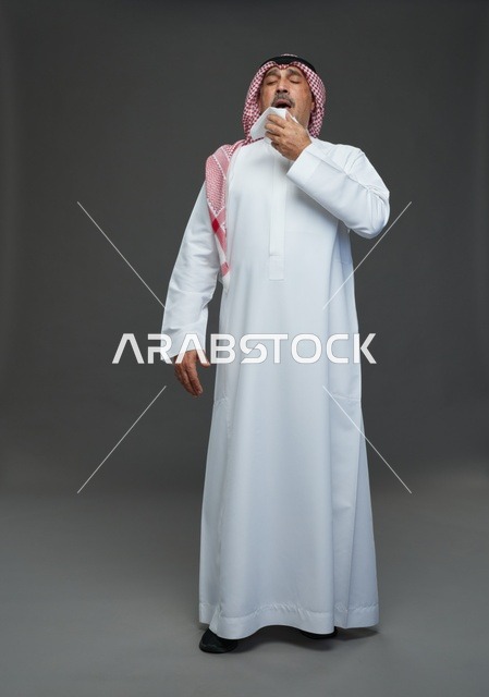 رجل سعودي يعطس في منديل على خلفية رمادية