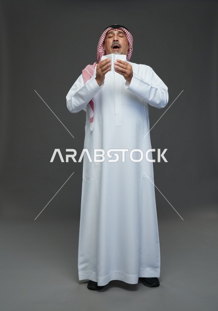 رجل سعودي مسن يعطس في منديل ورقي في استوديو تصوير