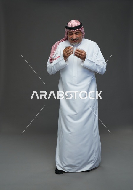 رجل سعودي مسن يعطس في منديل خلفية استوديو