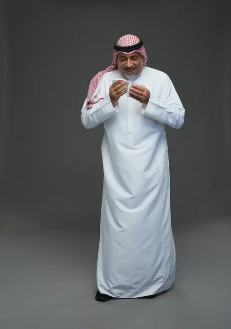 رجل سعودي مسن يعطس في منديل خلفية استوديو رجل سعودي مسن يعطس في منديل خلفية استوديو
