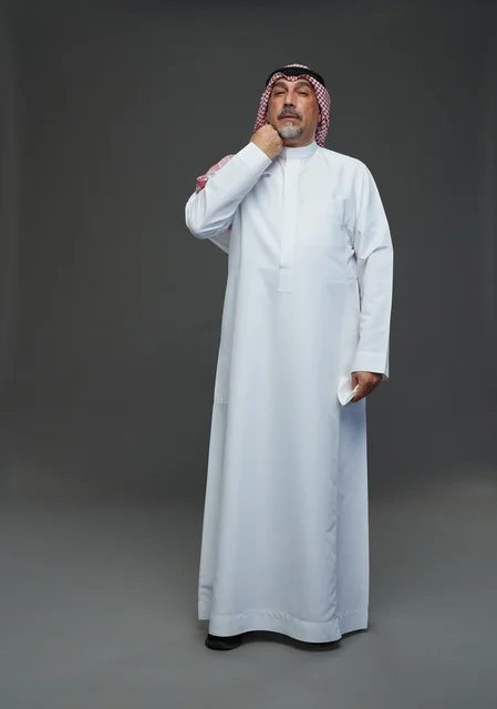 Elderly Saudi Man Sneezing into White Tissue in Studio