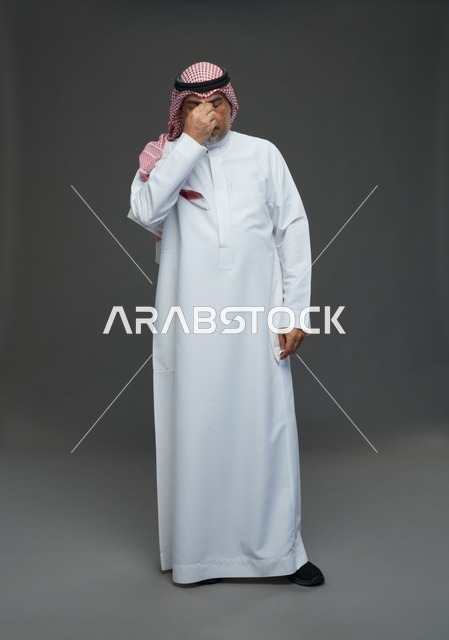 Elderly Saudi Man Sneezing into Tissue in Studio