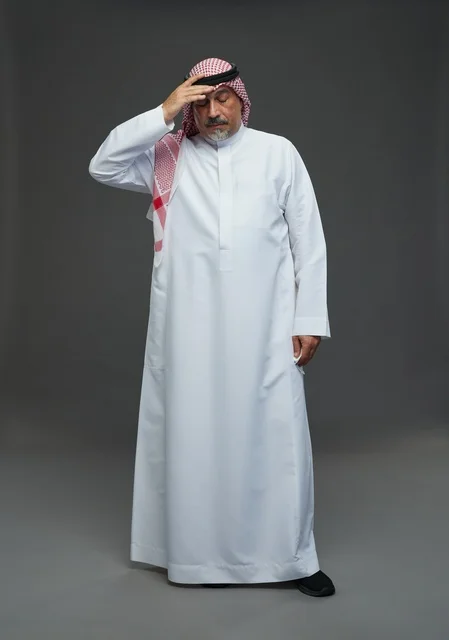 رجل سعودي مسن يعطس في منديل في الاستوديو