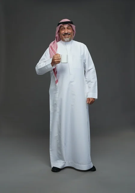 Senior Saudi Man with White Coffee Mug Standing in Studio
