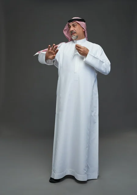 Elderly Saudi Man Sneezing into Tissue in Gray Studio