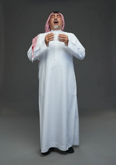 رجل سعودي مسن يعطس في منديل داخل الاستوديو